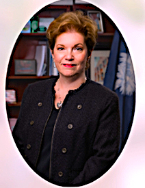 Women with short light brown hair, wearing a black dress. 
