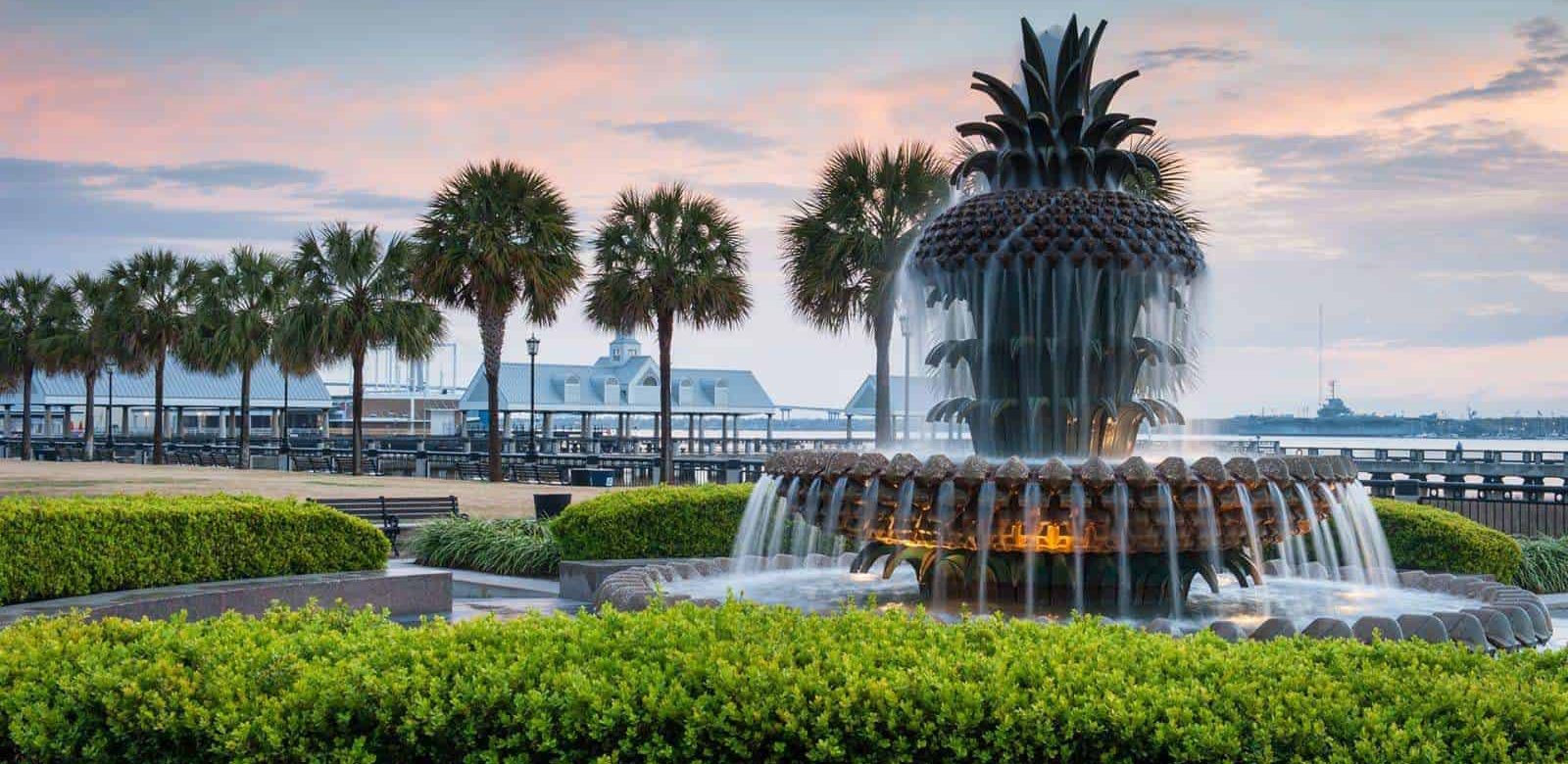 Water fountain shaped like a pineapple, with palm trees in the background